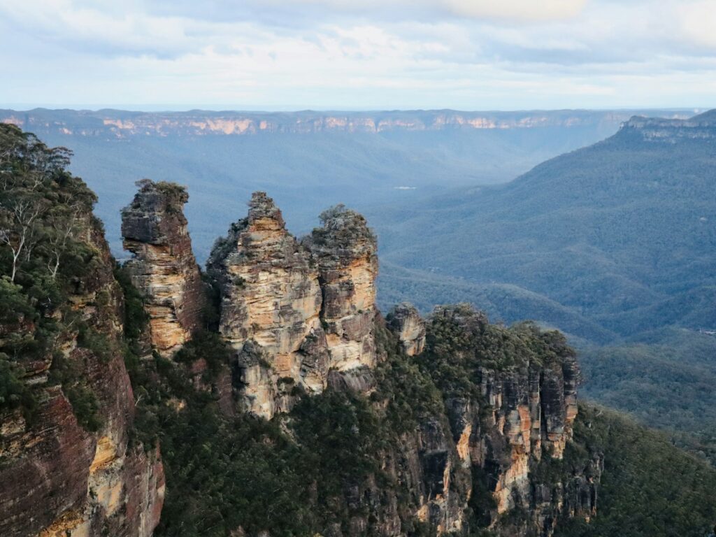 The Three Sisters rock formation above a forested valley in the Blue Mountains.